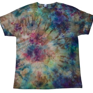 May include: A tie-dye t-shirt in a swirl of colors including brown, blue, purple, and green. The short-sleeved shirt has a crew neck and a small, light blue circle design on the front.