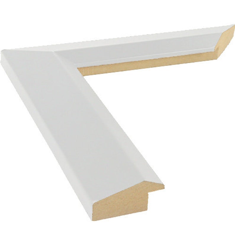 May include: A white picture frame corner, with a clean, angled design. The frame has a smooth, matte finish on the exterior, with a natural wood interior. The corner is cut at a 45-degree angle, ready for assembly.