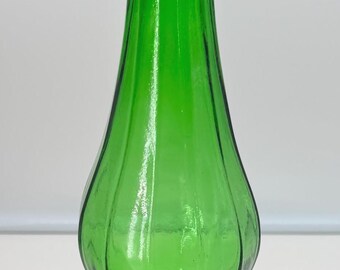 May include: A tall, vibrant green glass vase featuring a slender neck, a bulbous midsection, and a wide, fluted base. The entire surface of the vessel is characterized by vertical ridges that extend from the base up to the narrow opening.