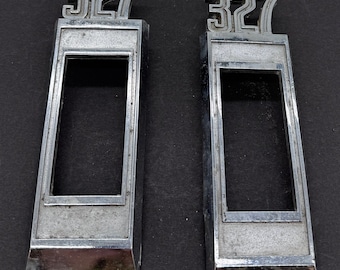 May include: Two silver-colored metal emblems with the number "327" embossed on them. Each emblem has a rectangular frame with a rectangular cutout in the center.