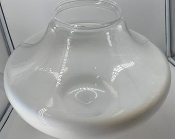 May include: A clear glass decorative bowl with a wide, rounded base and a narrow opening at the top. The glass has a slight frosted appearance, and the bowl is empty. The bowl is likely used for decorative purposes.