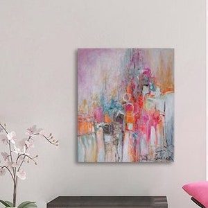 Op de afbeelding: Abstract schilderij met roze, rood, oranje, blauw en witte kleuren. Het schilderij heeft een textuur en is ingelijst in een wit frame.