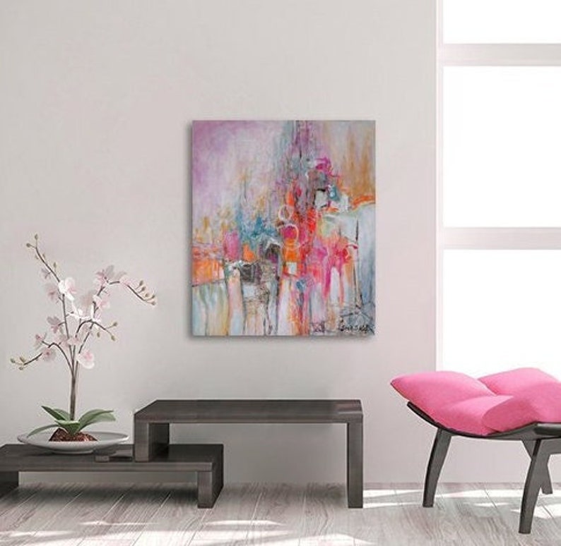 Op de afbeelding: Abstract schilderij met roze, rood, oranje, blauw en witte kleuren. Het schilderij heeft een textuur en is ingelijst in een wit frame.
