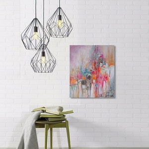 Op de afbeelding: Abstract schilderij met roze, oranje en blauwe tinten. Het schilderij hangt aan een witte bakstenen muur met drie zwarte geometrische hanglampen erboven.