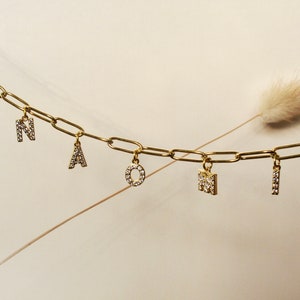 Collar personalizado con nombre, números y letras adornados con circonita cúbica y acabado en oro de 18 quilates.