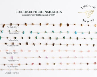 Op de afbeelding: Een collectie gouden kettingen met verschillende natuurlijke edelsteen kralen, waaronder tijgeroog, turquoise, malachiet, obsidiaan, rozenkwarts, amethist, toermalijn en aquamarijn. De kettingen worden getoond op een witte achtergrond met de tekst "COLLIERS DE PIERRES NATURELLES en acier inoxydable plaqué or 18K" en "LABOHEME B Gravure" boven de kettingen.