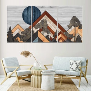May include: A three-panel wooden wall art piece featuring a mountain and tree design. The artwork uses various wood tones, including brown, orange, and gray, with a blue circle representing the sun or moon. The background is a light gray wood grain.
