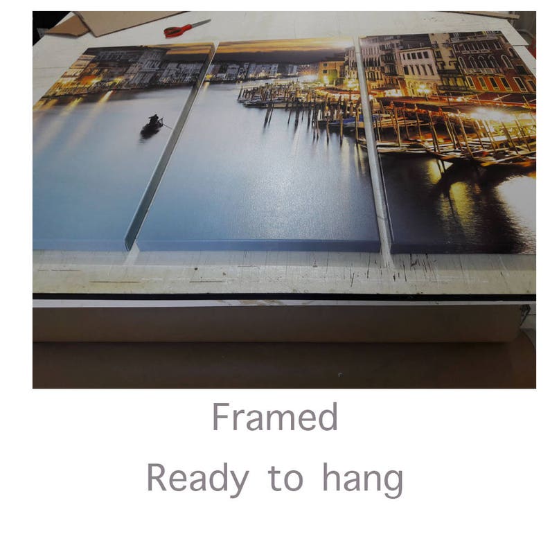 May include: A framed three-panel canvas print depicting a cityscape at night with a waterway in the foreground. The print is ready to hang.