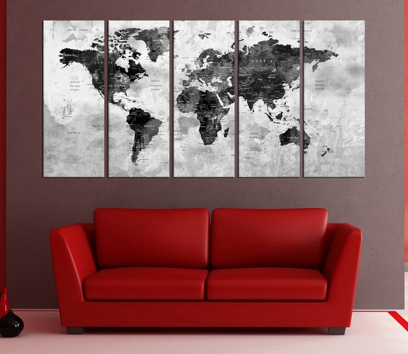 May include: A black and white world map print in a three-panel canvas set. The map is on a textured background with a distressed look. The map is displayed above a red couch.