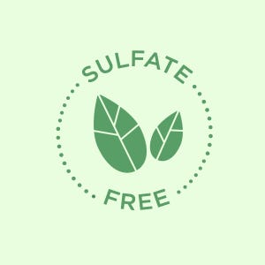 Op de afbeelding: Een groene cirkel met een witte gestippelde rand en de tekst "Sulfate Free" in wit. Twee groene bladeren bevinden zich in de cirkel.