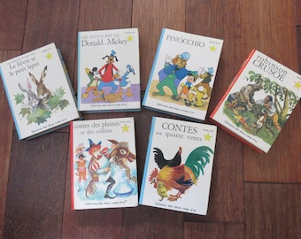 May include: A collection of six vintage children's books with colourful illustrations. The books are titled "Le lièvre et le petit lapin", "LES AVENTURES DE Donald Mickey", "PINOCCHIO", "robinson CRUSOE", "contes des plaines et des collines", and "CONTES aux quatre vents".