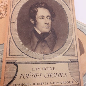 May include: A vintage book cover featuring a portrait of Alphonse de Lamartine, a French poet and politician. The title of the book is "Lamartine Po&eacute;sies Choisies" and the subtitle is "Classiques Illustr&eacute;s Vaubourdolle Librairie Hachette".
