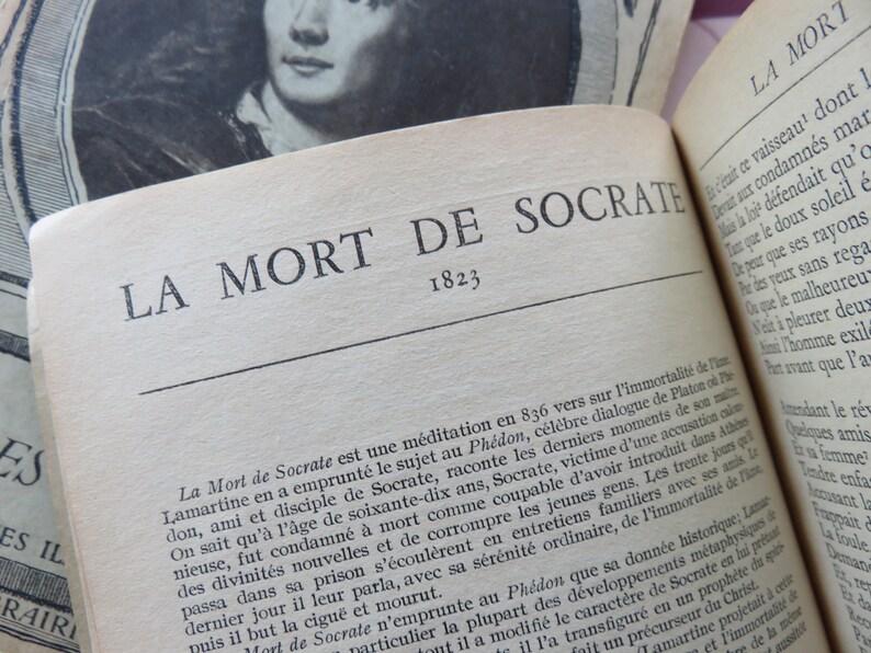 May include: A close-up of a book titled "La Mort de Socrate" with the year 1823 printed below the title. The book is open to a page with text about the death of Socrates.