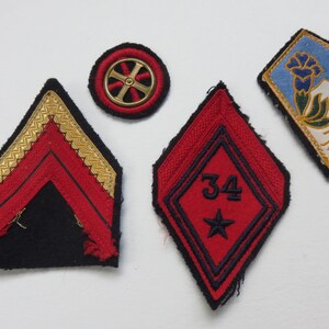 May include: Four embroidered patches, two red with gold trim, one blue with white and gold trim, and one black with a gold wheel design.