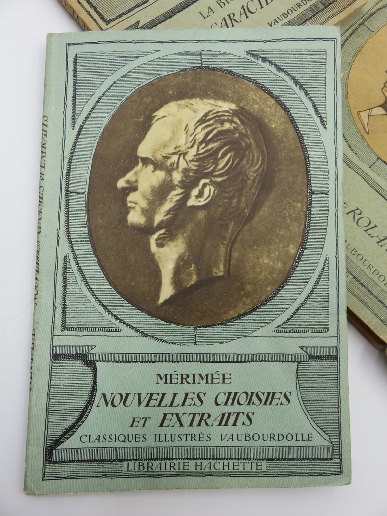 May include: A vintage book cover with a green background and a black and white portrait of a man. The title is "M&eacute;rim&eacute;e Nouvelles Choisies et Extraits" and the book is part of the "Classiques Illustr&eacute;s Vaubourdolle" series. The book is published by Librairie Hachette.