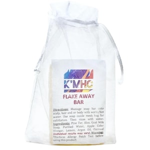 May include: A white mesh bag containing a rectangular bar of soap. The soap has the text "K'MHC FLAKE AWAY BAR" printed on it, along with usage directions and ingredients. The soap is designed for exfoliation.