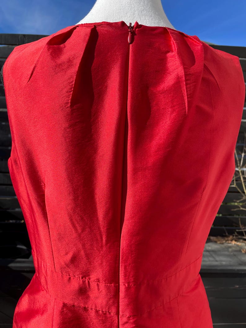 Puede incluir: Un vestido rojo sin mangas con una cremallera en la espalda.