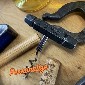 May include: A black metal corkscrew with a wooden handle. The corkscrew has a lever and a metal spiral. The handle is engraved with the words "I love you".