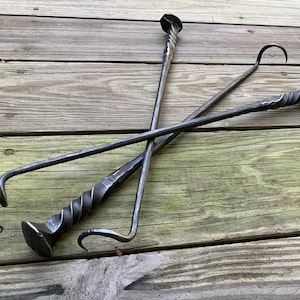 May include: Three metal fireplace tools with twisted handles. The tools have a hook, a poker, and a shovel.