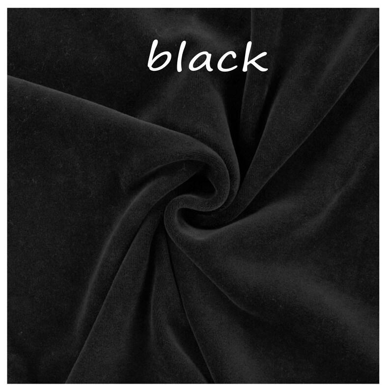 Op de afbeelding: Een stuk effen zwarte stof met een zachte, fluweelachtige textuur en een matte afwerking. Het materiaal is in het midden gedrapeerd om natuurlijke plooien en schaduwen te cre&euml;ren. Het woord "black" staat in witte tekst bovenaan de afbeelding.