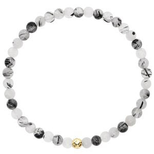 May include: A black and white beaded bracelet with a gold accent bead. The bracelet is made of natural stones and is approximately 7 inches in length.