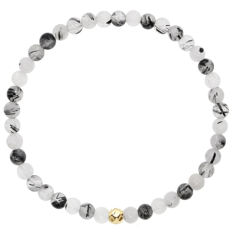 May include: A black and white beaded bracelet with a gold accent bead. The bracelet is made of natural stones and is approximately 7 inches in length.