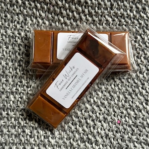 Puede incluir: Un paquete de cuatro velas de cera de soja con una etiqueta que dice "Four Wicks Handmade Soy Candles Vanilla Caramel Affair www.fourwickscandles.com".