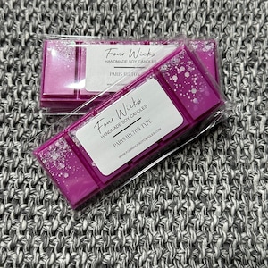 May include: Two wax melts in clear packaging with a pink and white design. The wax melts are labeled "Four Wicks Handmade Soy Candles" and "Paris Hilton Type".