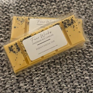 May include: A yellow wax melt bar with black flecks, packaged in clear plastic. The label reads "Four Wicks Handmade Soy Candles" and "Perfect Intense Type" with the website address "www.fourwicksoycandles.com".