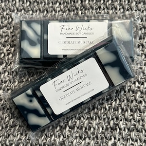 May include: Two wax melts in clear packaging. The wax melts are black and white with a marbled design. The packaging has a white label with the text "Four Wicks Handmade Soy Candles Chocolate Mud Cake WWW.FOURWICKSOYCANDLES.COM"
