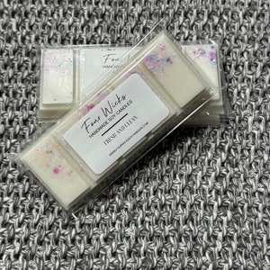 May include: A white wax melt with a fresh and clean scent. The wax melt is packaged in a clear plastic container with a label that reads "Four Wicks Handmade Soy Candles Fresh and Clean www.fourwicksoycandles.com".