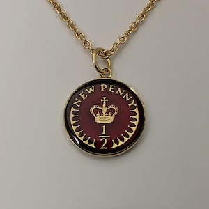 Può includere: Collana color oro con un ciondolo circolare. Il ciondolo presenta uno sfondo rosso con una corona dorata e le parole "NEW PENNY". Il numero "1/2" è sotto la corona. La catena è in stile a maglie delicate.