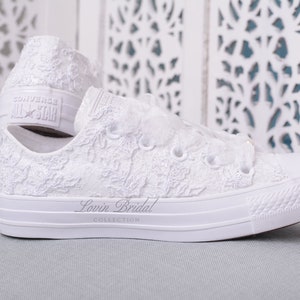 Elegant lace-adorned white Converse for brides. Personalize your special day with these luxury low-top tennis shoes featuring exquisite Dubai lace. Perfect for the fashion-forward bride seeking comfort and style on her wedding day