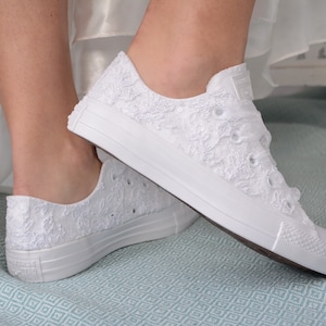 Elegant lace-adorned white Converse for brides. Customizable low-top tennis shoes with Dubai lace. Perfect for a luxurious wedding, adding style and comfort to the bride's special day