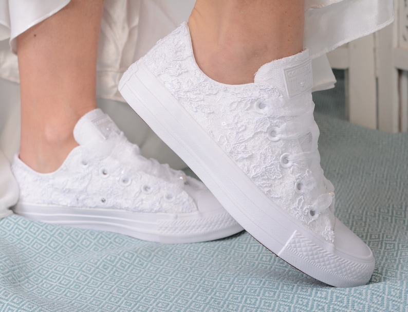 Elegant lace-adorned Converse for brides, a luxurious choice. Personalized low top tennis shoes in pristine white. Perfect for a wedding, featuring exquisite Dubai lace. Bridal bliss in every step.