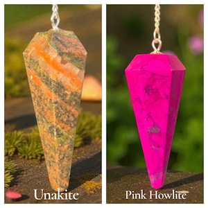 May include: Two gemstone pendulums suspended by silver chains. One is Unakite, with green, orange, and brown patterns. The other is Pink Howlite, a vibrant magenta color. The pendulums are faceted and cone-shaped.