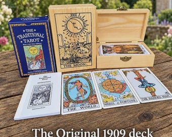May include: A tarot card deck set including a blue box labeled The Traditional Tarot, a wooden box with a Moon card illustration, an instruction booklet, and three cards: The World, Wheel of Fortune, and The Hanged Man.
