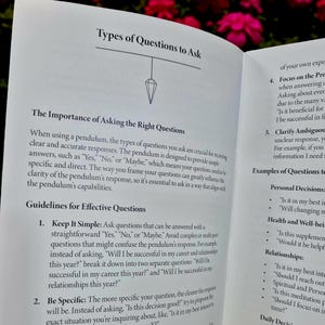 May include: Open book page with text about using a pendulum for guidance. The page includes the title "Types of Questions to Ask" and discusses the importance of asking clear and specific questions for accurate answers.