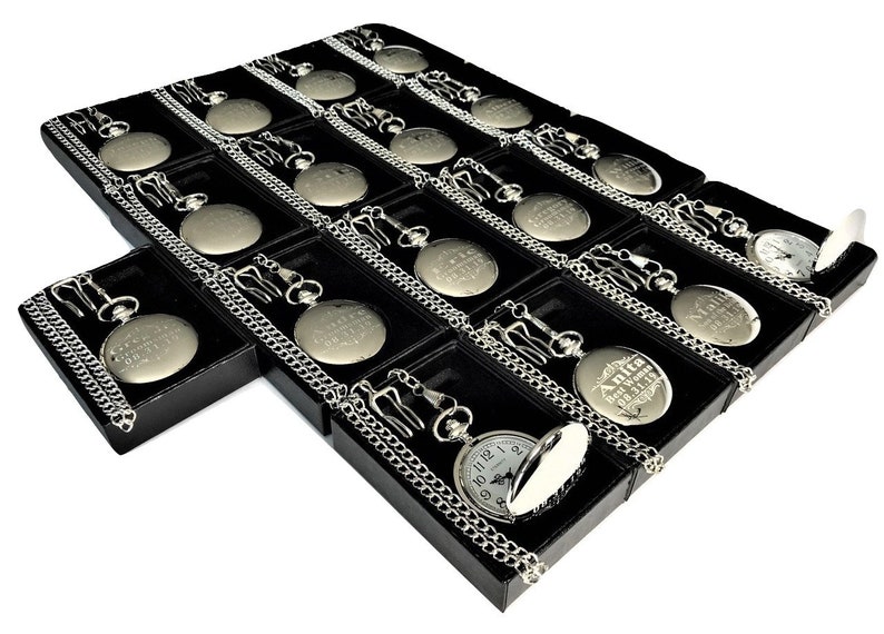 Puede incluir: Una muestra de relojes de bolsillo plateados con cadenas en cajas de terciopelo negro. Cada reloj tiene una inscripci&oacute;n grabada.