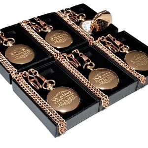 Puede incluir: Seis relojes de bolsillo dorados con cadenas en cajas negras. Cada reloj tiene una inscripci&oacute;n personalizada con un nombre y la fecha "10.26.2019".