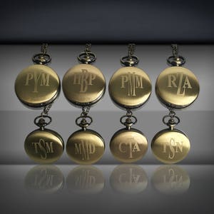 Puede incluir: Siete relojes de bolsillo dorados con iniciales grabadas en la parte delantera. Las iniciales son PYM, HBP, PMM, RZA, TSM, MMD y CTA.
