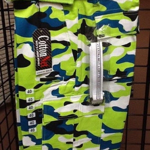 May include: Camouflage cargo shorts with a green belt and a white tag that says "Cotton Net" and "Men's Cargo Short". The tag also has a price of $44.99. The shorts have a pocket on the side with a label that says "An extra belt a gift from Cottonnet".