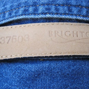 May include: A brown leather belt with the text "M 37600" and "BRIGHTON" embossed on it.