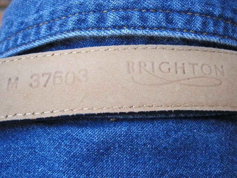 May include: A brown leather belt with the text "M 37600" and "BRIGHTON" embossed on it.
