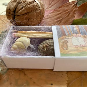 12 Schachteln mit Illustrationen aus der Vergangenheit, gefüllt mit Bienenwachskerzen, farbigen Streichhölzern und handgefärbter Schafwolle. Waldorf-Handout-Geschenk