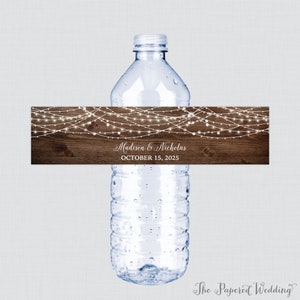 May include: Water bottle label with a rustic wood background and white string lights. The label says "Madison & Nicholas" and "October 15, 2025".
