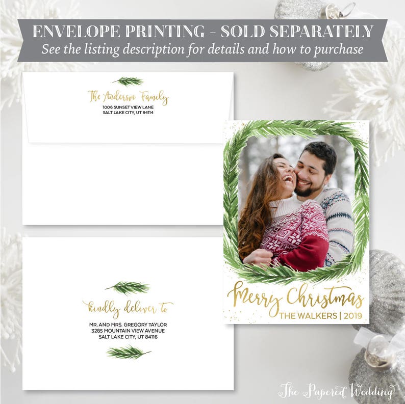 May include: Christmas card with a photo of a couple inside a green wreath, with the words "Merry Christmas" and "The Walkers | 2019". Includes white envelopes with gold text: "The Anderson Family" and "Kindly deliver to Mr. and Mrs. Gregory Taylor".