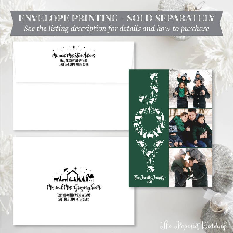May include: A holiday card with a green background and the word "JOY" in white, filled with nativity scene silhouettes. Includes family photos and two white envelopes with printed addresses. The text reads "The Jacobs Family 2017."