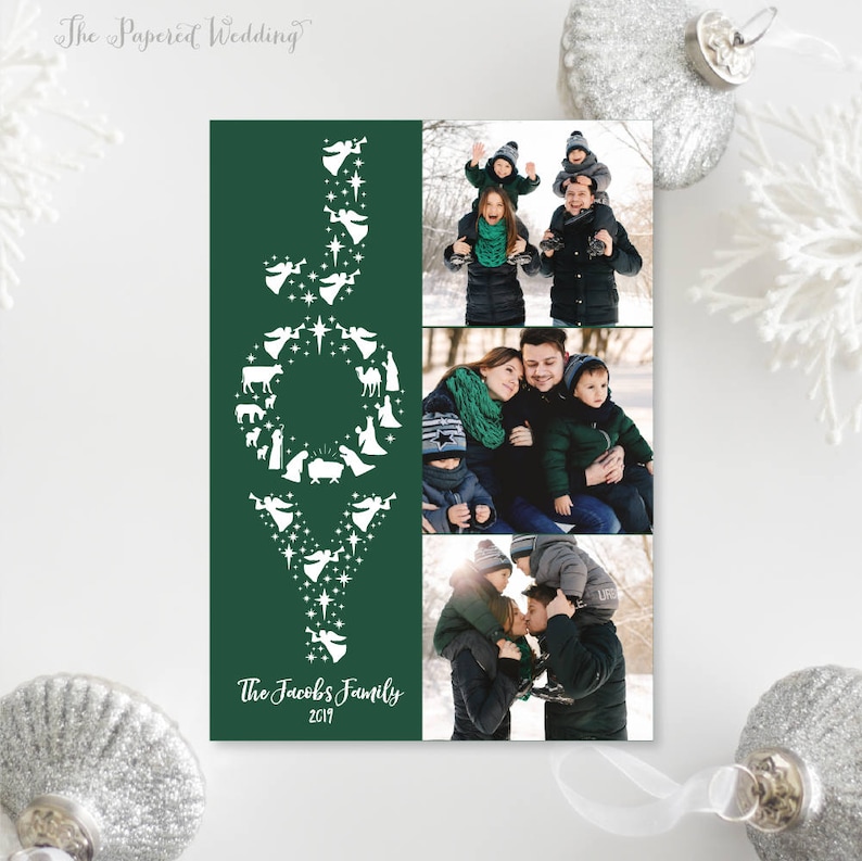 May include: A Christmas card with a dark green background and the word "JOY" in white, decorated with nativity scene silhouettes. The card includes family photos and the text "The Jacobs Family 2019".