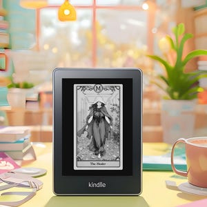 May include: A black and white illustration of a woman in a long robe with a hood, walking on a path with white paper birds. The image is displayed on a Kindle e-reader, which is sitting on a yellow surface. The text on the card reads "The Healer".